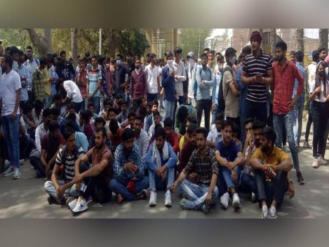 पर्वतारोही नरेंद्र परीक्षा केंद्र के बाहर ब्लू टूथ के माध्यम से प्रश्नों के उत्तर लिखवा रहा था। पर्वतारोही नरेंद्र परीक्षा केंद्र के बाहर ब्लू टूथ के माध्यम से प्रश्नों के उत्तर लिखवा रहा था।